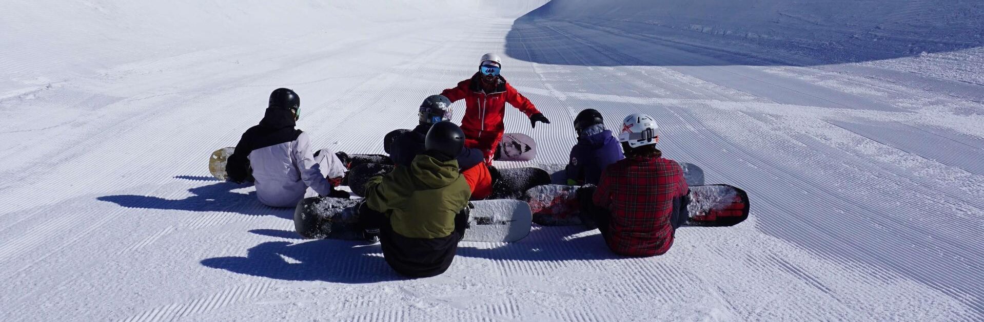 Gruppe von Snowboardern mit Snowboardlehrer