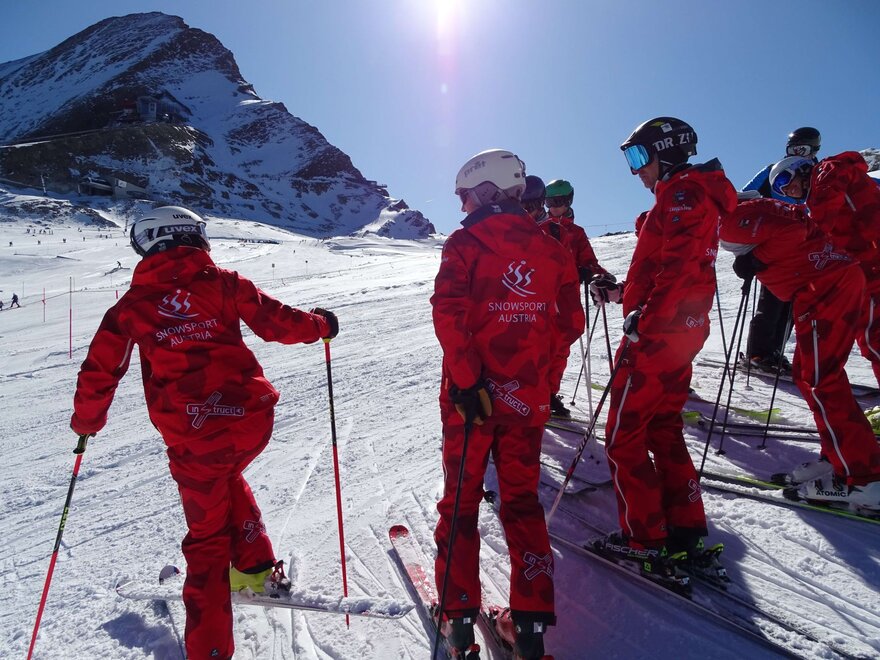 Gruppe von Skilehrern steht an der Piste