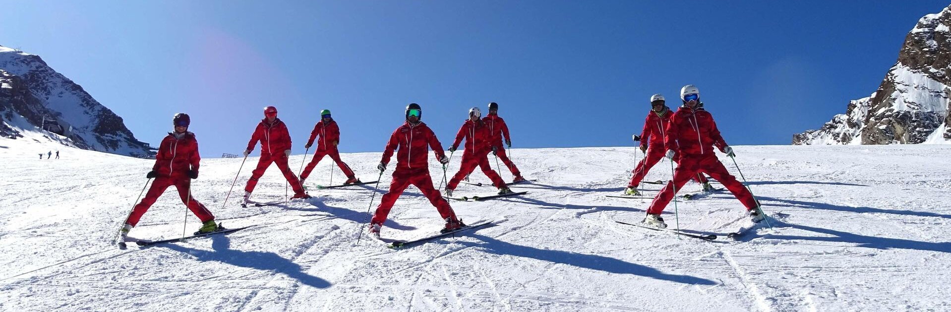 Gruppe von Skilehrern fährt im Pflug 