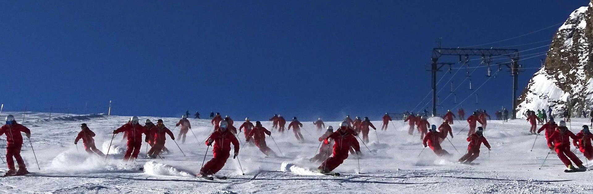 Große Gruppe von Skilehrern bei der Abfahrt